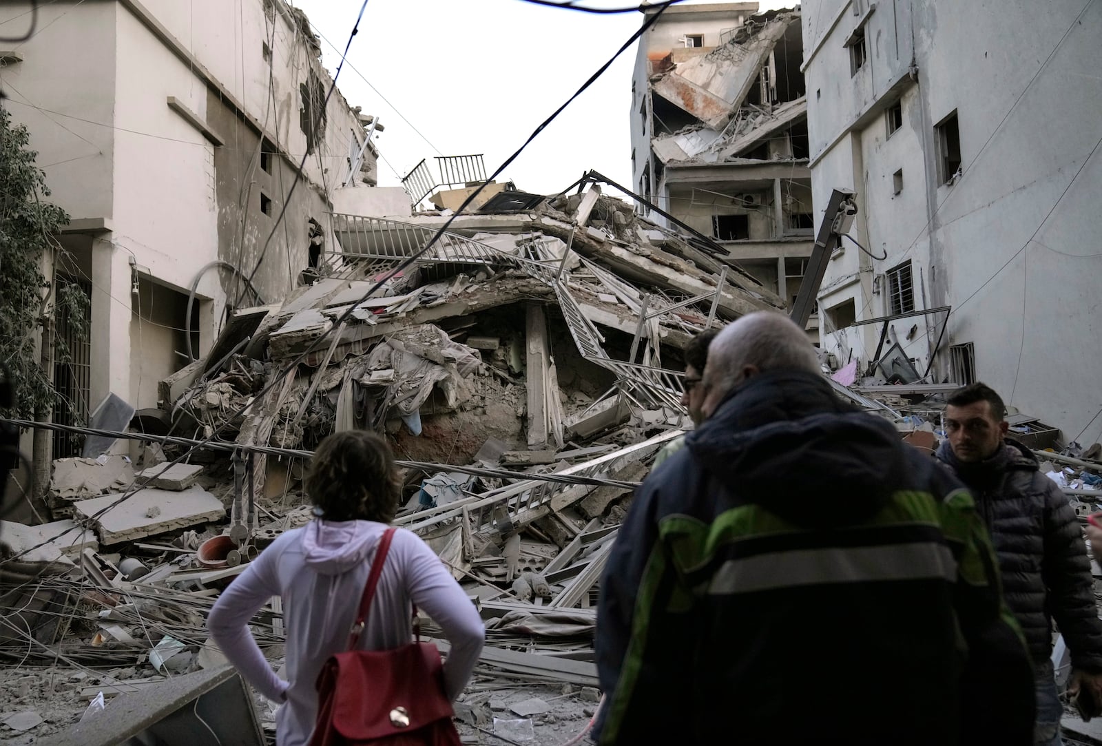 Residents check their destroyed building hit in an Israeli airstrike in Dahiyeh, in the southern suburb of Beirut, Lebanon, Thursday, Nov. 14, 2024. (AP Photo/Hussein Malla)