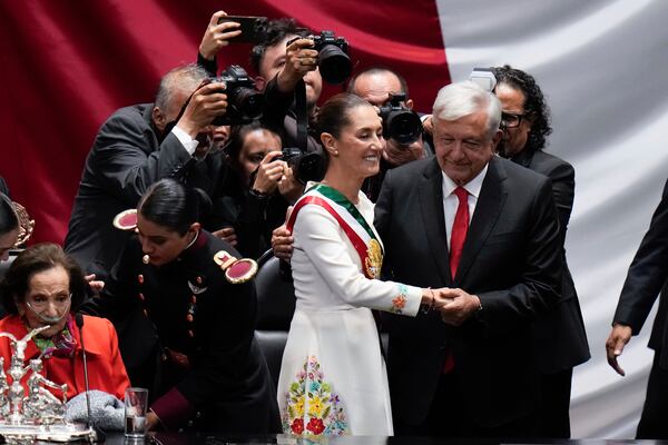 FILE - President Claudia Sheinbaum holds hands with outgoing President Andres Manuel López Obrador after taking the oath of office in the lower chamber of Congress, in Mexico City, Tuesday, Oct. 1, 2024. (AP Photo/Eduardo Verdugo, file)