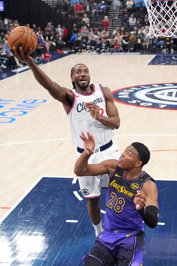 Los Angeles Clippers forward Kawhi Leonard, top, shoots as Los Angeles Lakers forward Rui Hachimura defends during the first half of an NBA basketball game, Sunday, Jan. 19, 2025, in Inglewood, Calif. (AP Photo/Mark J. Terrill)