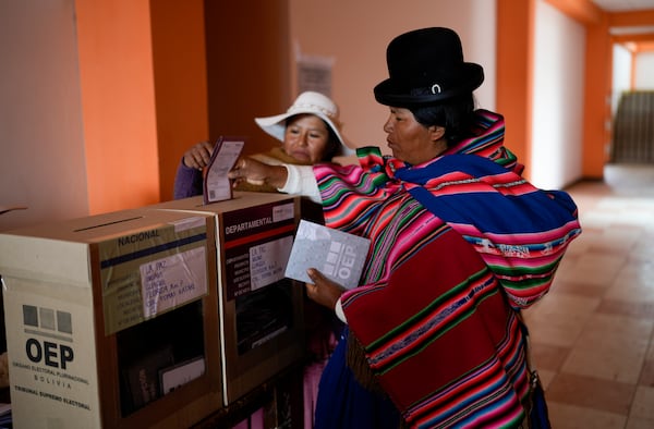 An Aymaran woman casts her ballot at a polling station during judicial elections in Guaqui, Bolivia, Sunday, Dec. 15, 2024. (AP Photo/Juan Karita)