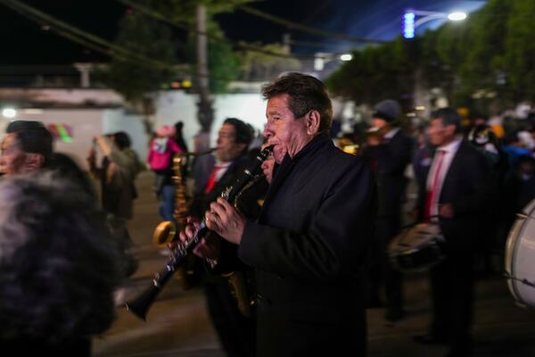 Musicians play at the back end of a procession with a replica of the Black Christ of Esquipulas statue the night before its feast day in Esquipulas Palo Gordo, in Guatemala's San Marcos department, Tuesday, Jan. 14, 2025. (AP Photo/Moises Castillo)