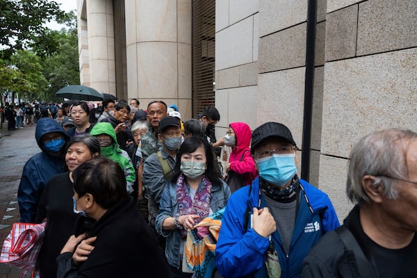 People wait outside the West Kowloon Magistrates' Courts in Hong Kong Tuesday, Nov. 19, 2024, ahead of the sentencing in national security case. (AP Photo/Chan Long Hei)