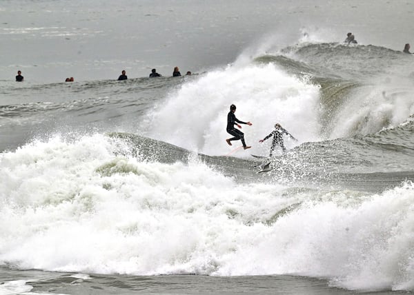 Surfers take to the water as big waves hit the shore in Seal Beach, Calif., Monday, Dec. 23, 2024. (Jeff Gritchen/The Orange County Register via AP)