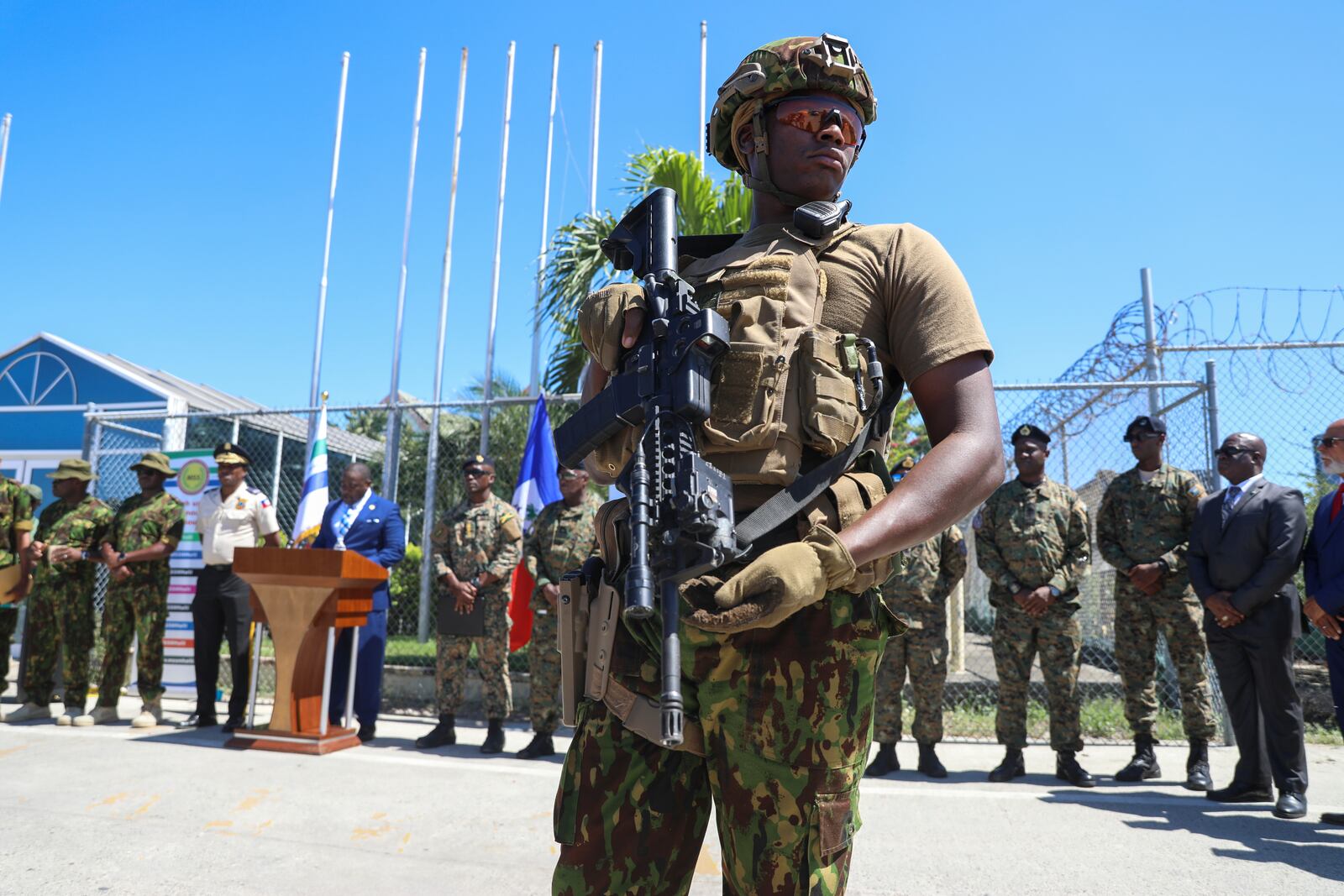 A Kenyan police officer, part of a UN-backed multinational force, stands guard on the tarmac during a ceremony to welcome police officers from the Bahamas at the Toussaint Louverture International Airport in Port-au-Prince, Haiti, Friday, Oct. 18, 2024. (AP Photo/Odelyn Joseph)