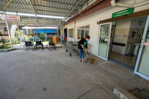 A woman cleans near the emergency section of a hospital where poisoned foreign tourists admitted in Vang Vieng, Laos, Friday, Nov. 22, 2024. (AP Photo/Anupam Nath)