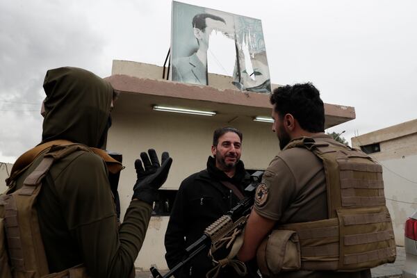 A member of Bashar Assad's army, or a pro-government militia, talks to members of the security forces of the newly formed Syrian government as he takes part in an "identification and reconciliation" process in Damascus, Syria, Monday, Dec. 30, 2024. (AP Photo/Omar Sanadiki)