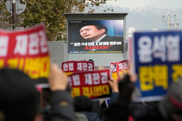 Supporters for impeached South Korean President Yoon Suk Yeol stage a rally against his impeachment near the Constitutional Court in Seoul, South Korea, Friday, Dec. 20, 2024. A screen reads "Let's protect President Yoon Suk Yeol!" (AP Photo/Ahn Young-joon)