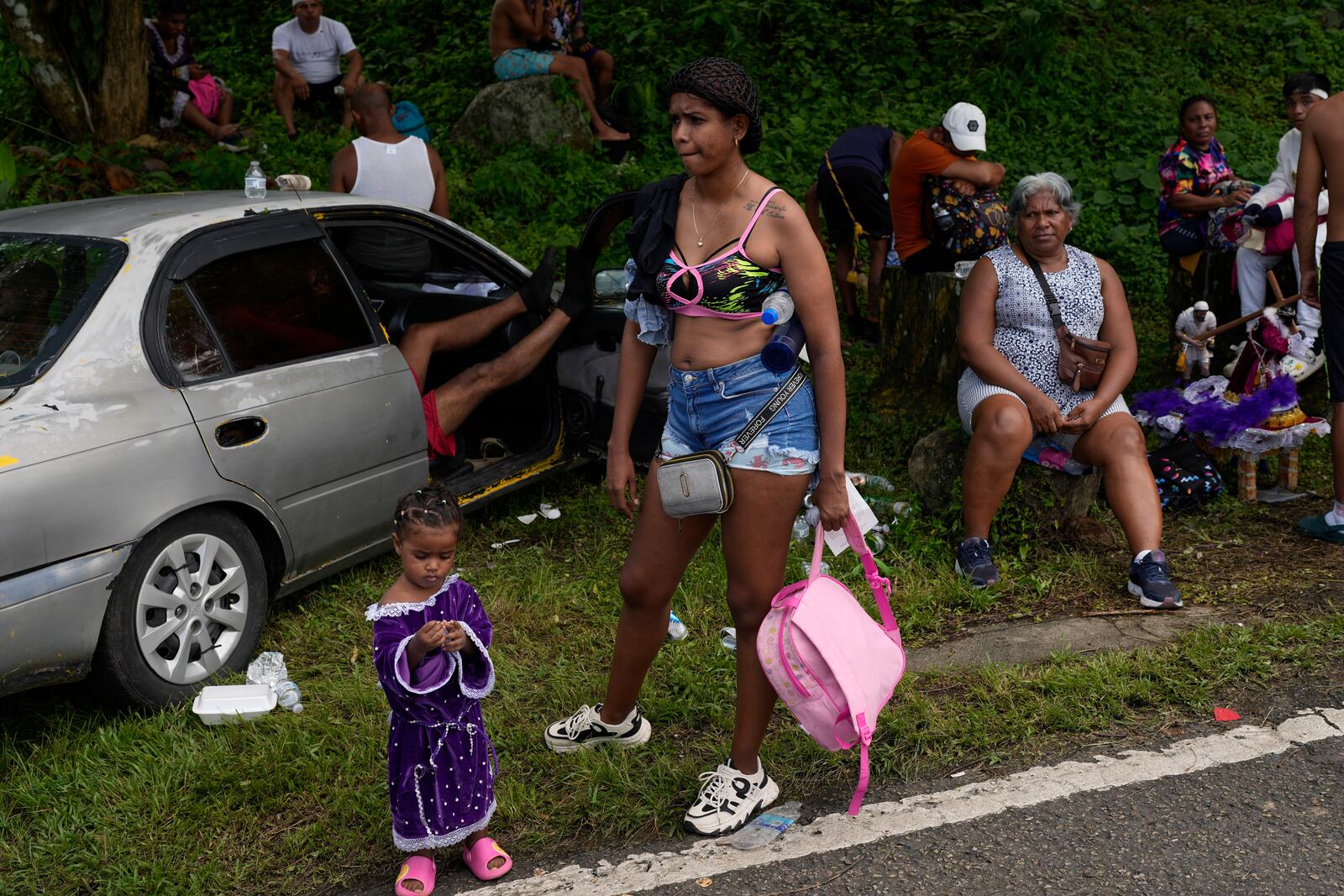 Pilgrims rest on the side of the road after leaving San Felipe Church to honor the Black Christ in Portobelo, Panama, Monday, Oct. 21, 2024, during a festival celebrating the iconic statue that was found on the shore in 1658. (AP Photo/Matias Delacroix)