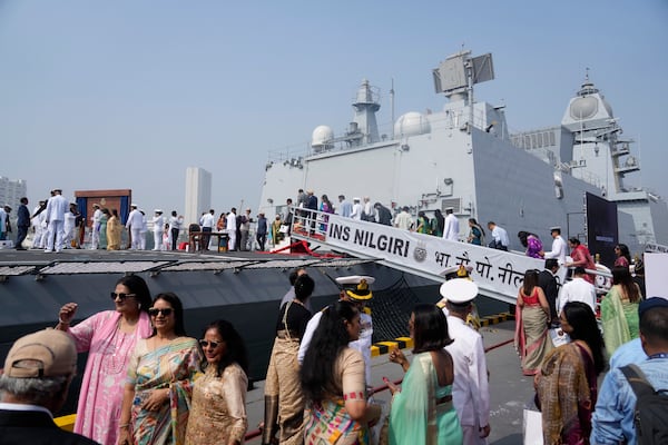 Indian naval officers walk with their family members after the commissioning of INS Nilgiri at a naval dockyard in Mumbai, India, Wednesday, Jan. 15, 2025. (AP Photo/Rafiq Maqbool)