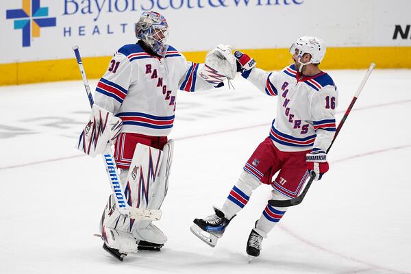 New York Rangers' Igor Shesterkin (31) and Vincent Trocheck (16) celebrate the team's win in an NHL hockey game against the Dallas Stars in Dallas, Friday, Dec. 20, 2024. (AP Photo/Tony Gutierrez)