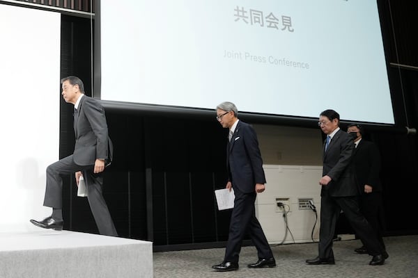 Nissan Chief Executive Makoto Uchida, left, and Honda Chief Executive Toshihiro Mibe, center, and Takao Kato CEO of Mitsubishi Motors, right, arrive to attend a joint news conference Monday, Dec. 23, 2024, in Tokyo, Japan. (AP Photo/Eugene Hoshiko)