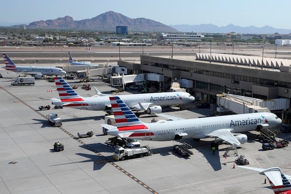 FILE - American Airlines planes wait at gates at Phoenix Sky Harbor International Airport Friday, July 19, 2024, in Phoenix. (AP Photo/Ross D. Franklin, File)