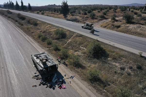 A Syrian army armoured vehicle sits abandoned on a highway in the outskirts of Khan Sheikhoun, southwest of Aleppo, Sunday, Dec. 1, 2024. Syrian opposition insurgency launched a campaign on Wednesday with a two-pronged attack on Aleppo and the countryside around Idlib.(AP Photo/Ghaith Alsayed)