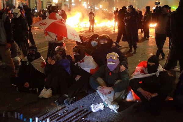 Demonstrators sit in front of police protesting against the government's decision to suspend negotiations on joining the European Union in Tbilisi, Georgia, early Tuesday, Dec. 3, 2024. (AP Photo/Zurab Tsertsvadze)