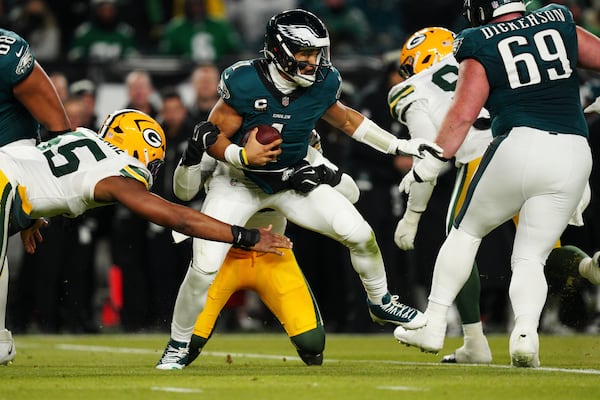 Philadelphia Eagles quarterback Jalen Hurts (1) is sacked by Green Bay Packers defensive end Rashan Gary (52) as Green Bay Packers defensive end Kingsley Enagbare (55) narrows in during the second half of an NFL wild-card playoff football game Sunday, Jan. 12, 2025, in Philadelphia. (AP Photo/Derik Hamilton)